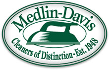 Medlin Davis Cleaners Logo - Oval with 2 line green stroke holding green serif type and hand iron